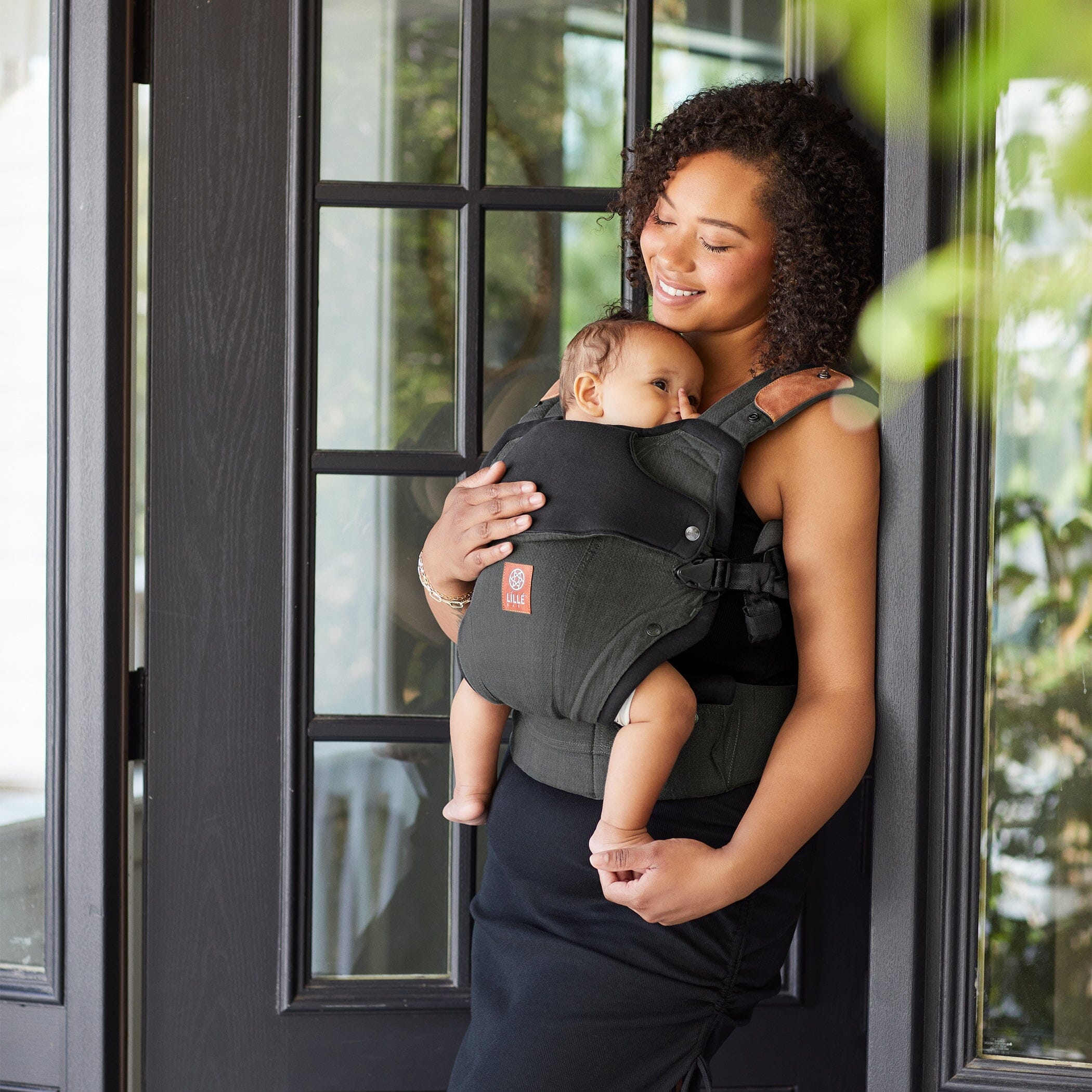 Mom wearing baby in elevate carrier in Pewter
