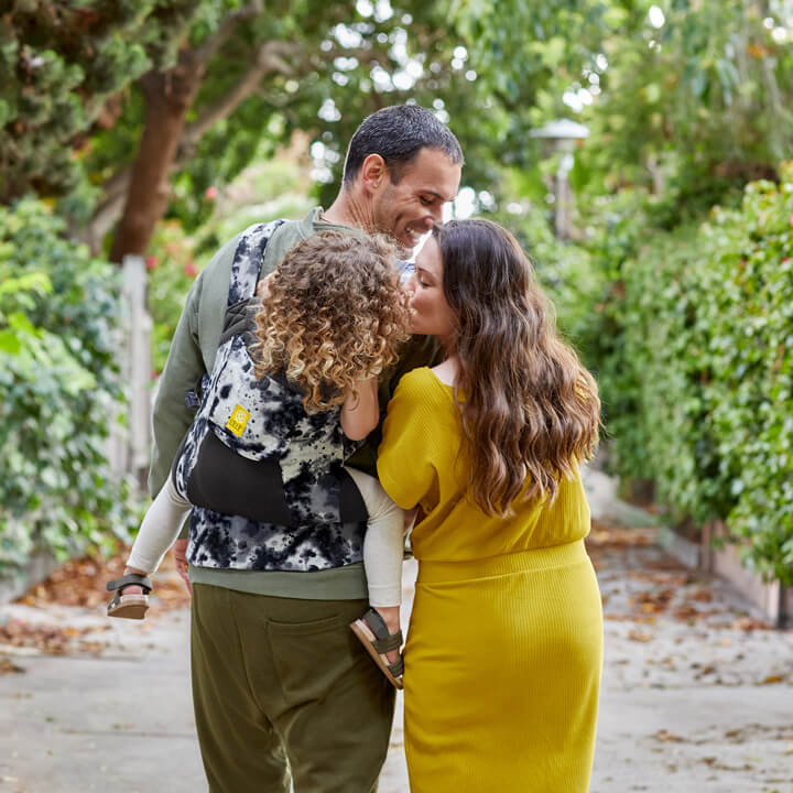 Mom helping Dad carry their daughter in the LILLEbaby CarryOn Airflow DLX carrier