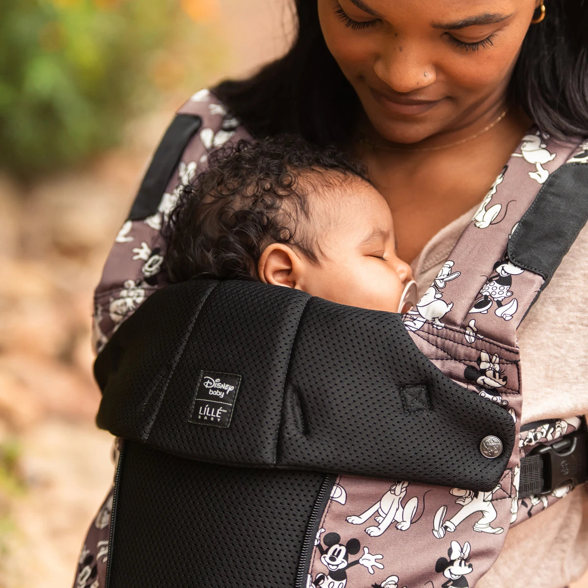 mom wearing baby in the Complete 6-in-1 All Seasons in Mickey & Friend's Jamboree baby carrier