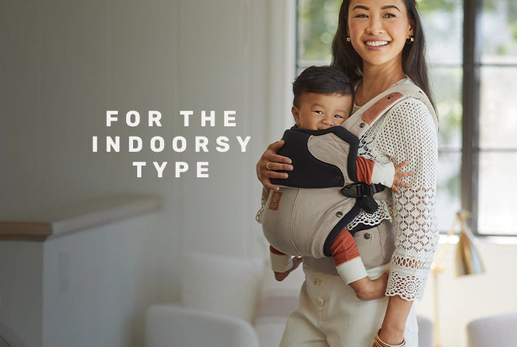 for the indoorsy type. mom wearing baby in the elevate carrier in warm sand