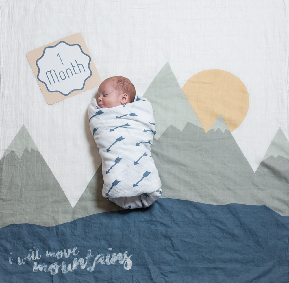 1 month old baby in lulujo blanket in i will move mountains pattern