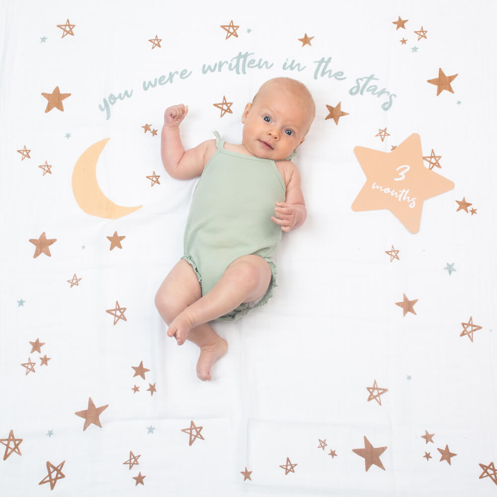 3 month old baby on lulujo's blanket in written in stars pattern