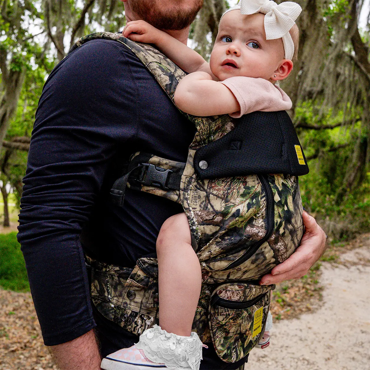 dad wearing baby in complete all seasons carrier in collaboration with mossy oak