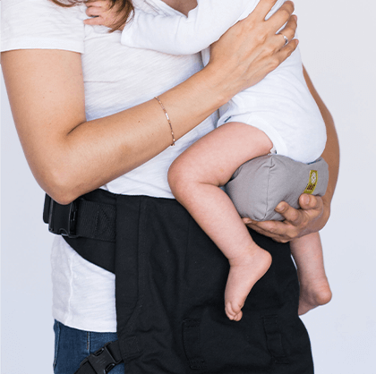 Mom in white shirt holding baby from his bottom