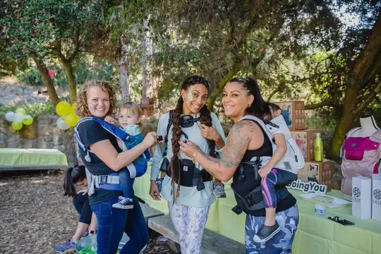 Parents holding their babies in LILLEbaby carriers