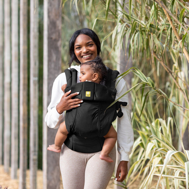 mom wearing baby in lillebaby complete all seasons baby carrier in black