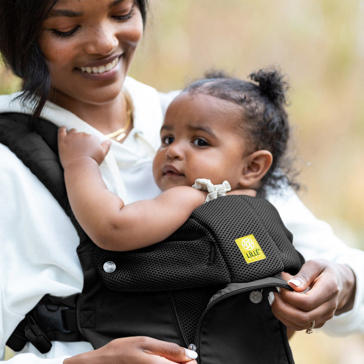 mom wearing baby in lillebaby complete all seasons baby carrier in black