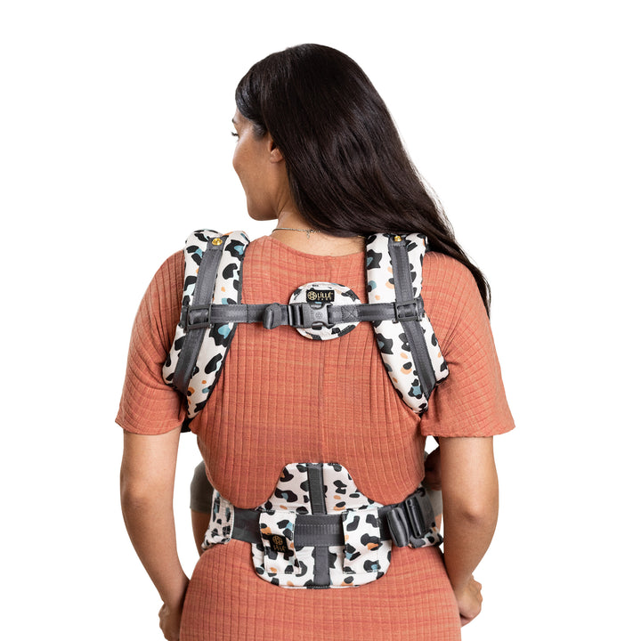 back image of mom wearing baby in lillebaby complete luxe baby carrier in desert leopard