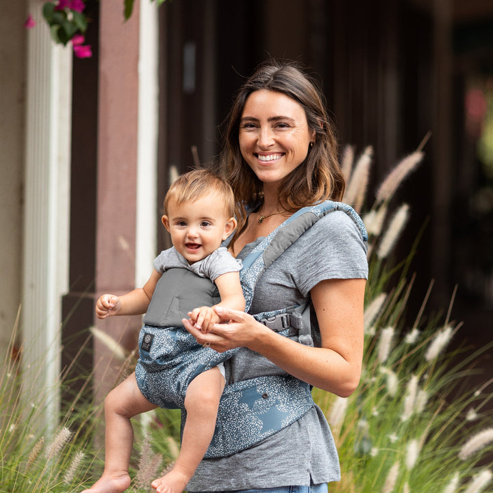 mom wearing baby in lillebaby complete luxe baby carrier in starfall