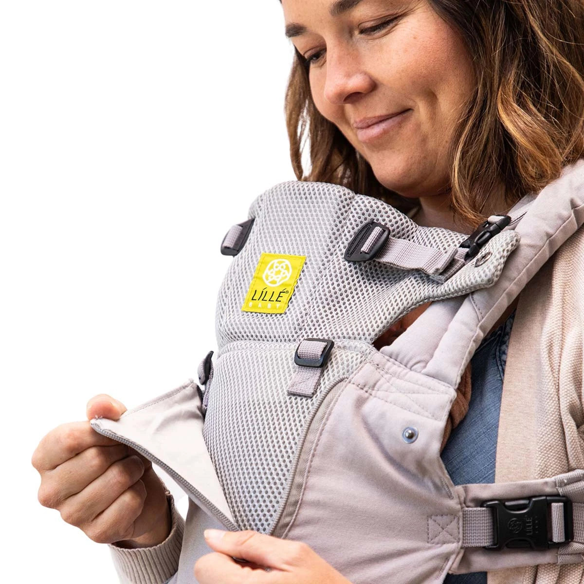 Complete All Seasons carrier shown with newborn while mom unzips temparature control panel to reveal mesh layer for airflow