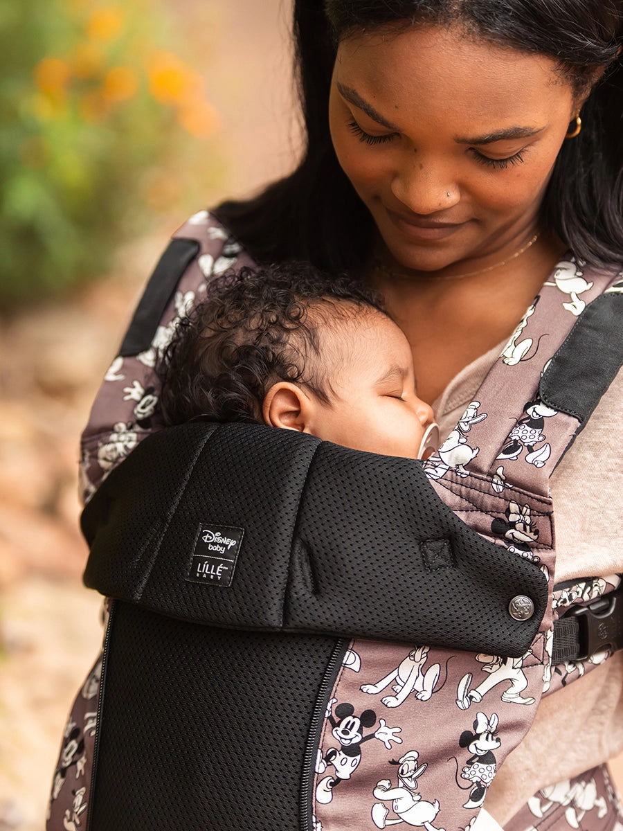 mom wearing baby in complete all seasons carrier in Mickey & Friend's Jamboree