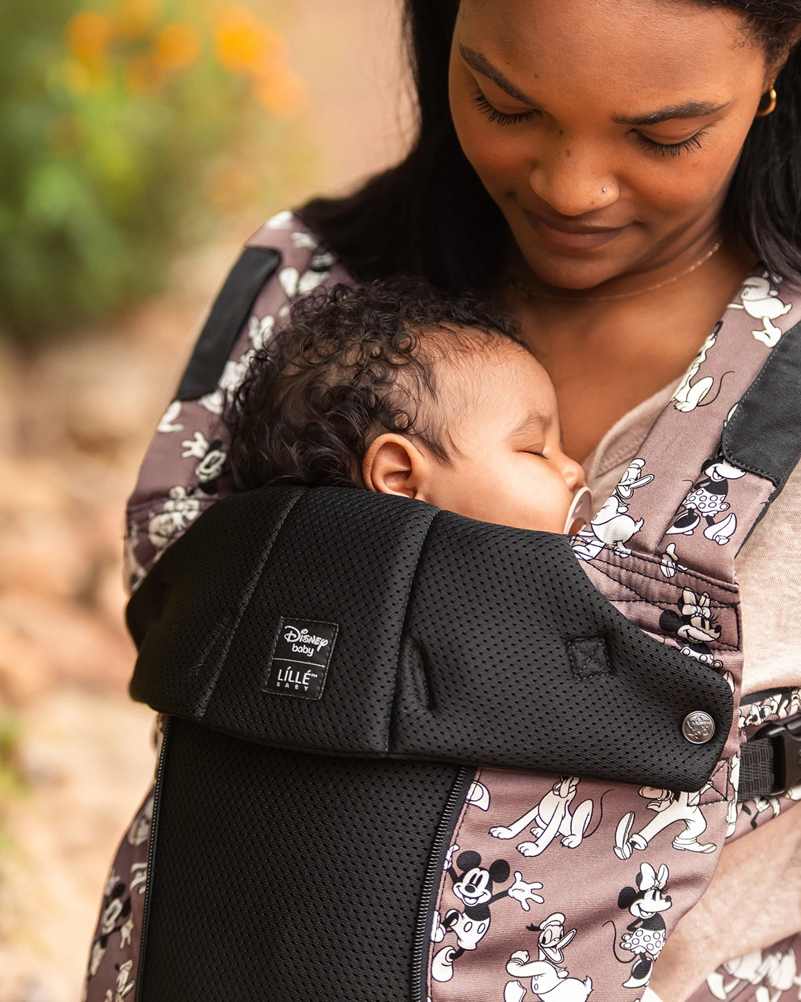 mom wearing baby in complete all seasons carrier in Mickey & Friend's Jamboree