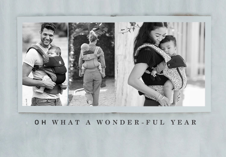 oh what a wonder-ful year. mom and dads wearing baby in complete all seasons baby carriers
