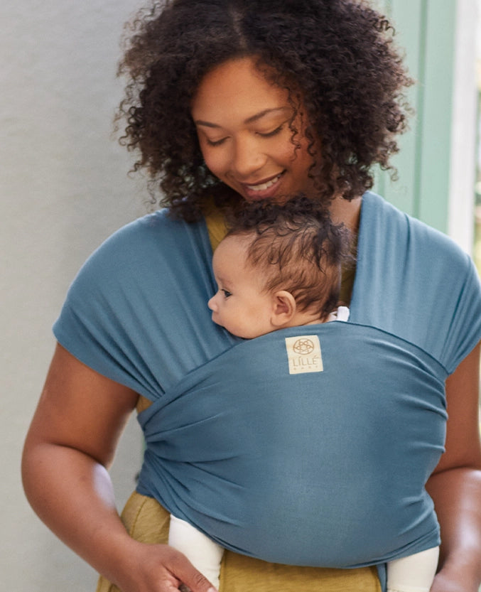 mom wearing baby in dragonfly wrap in bluestone