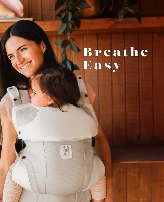 breathe easy - mom wearing elevate carrier in ivory.