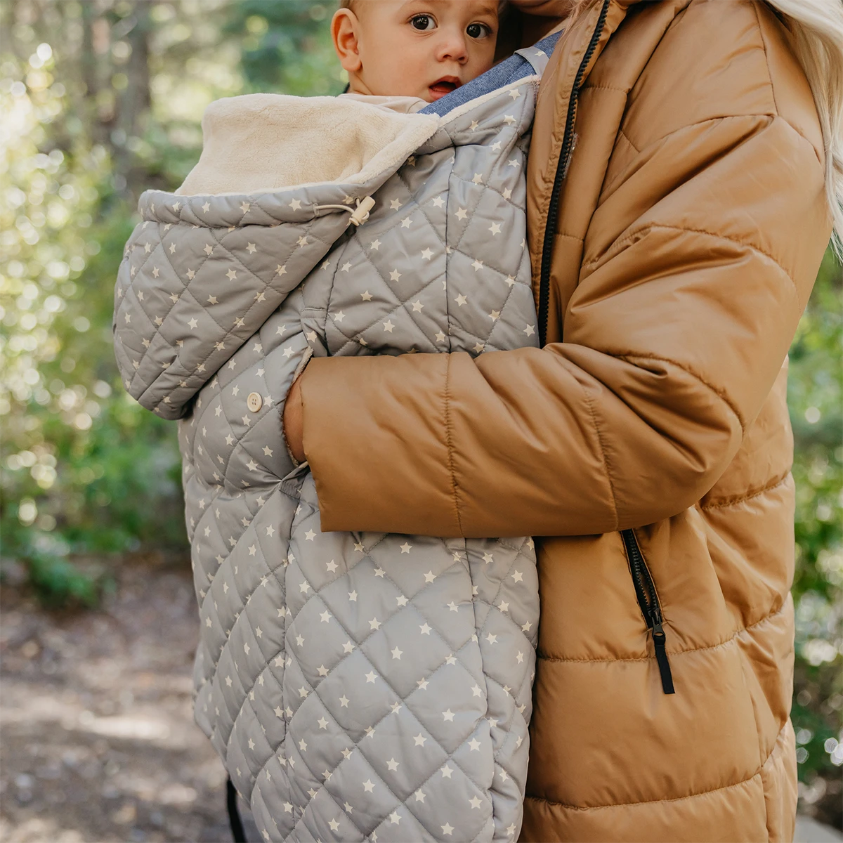 mom wearing baby in All seasons in chambray and K-poncho in gray stars