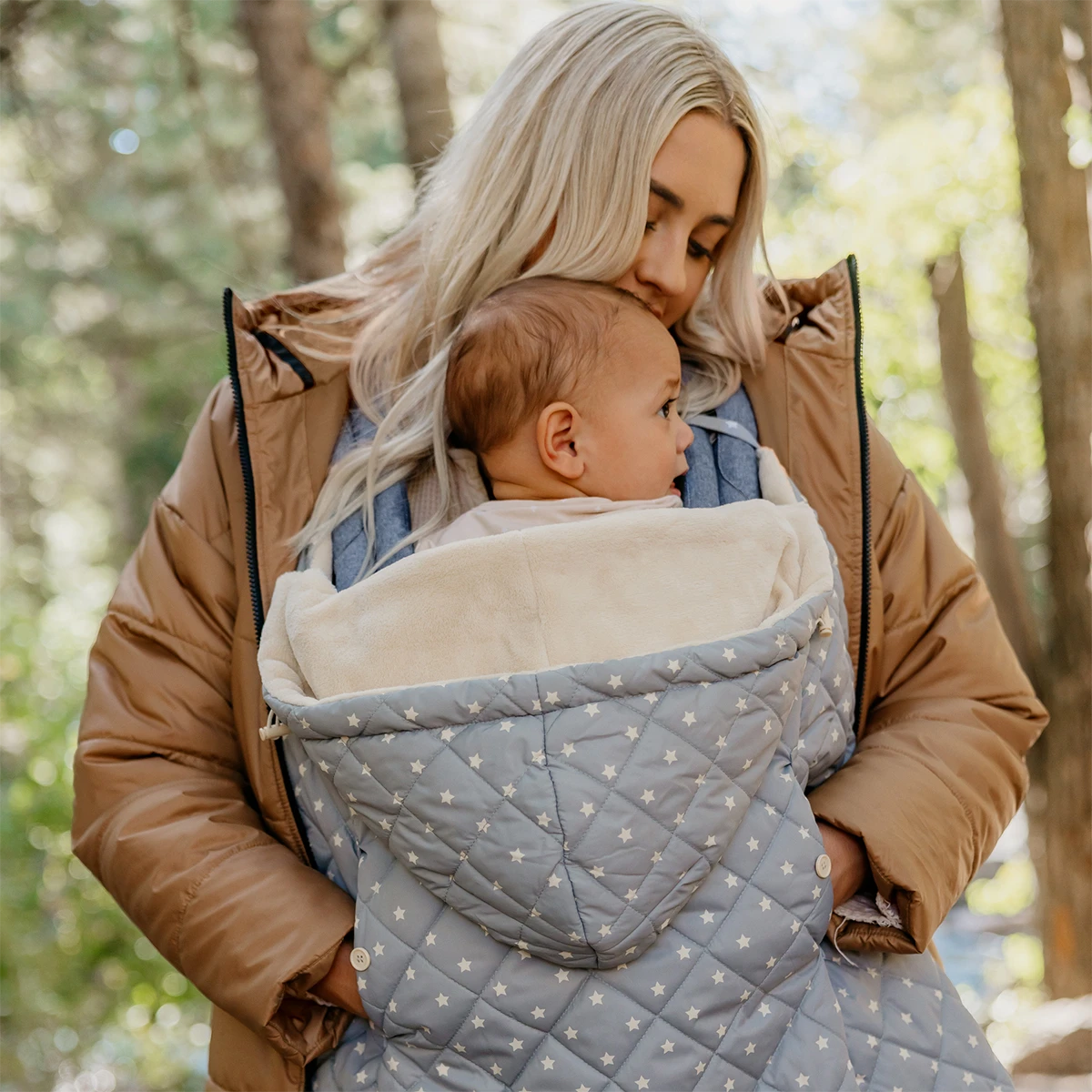 mom wearing baby in All seasons in chambray and K-poncho in gray stars