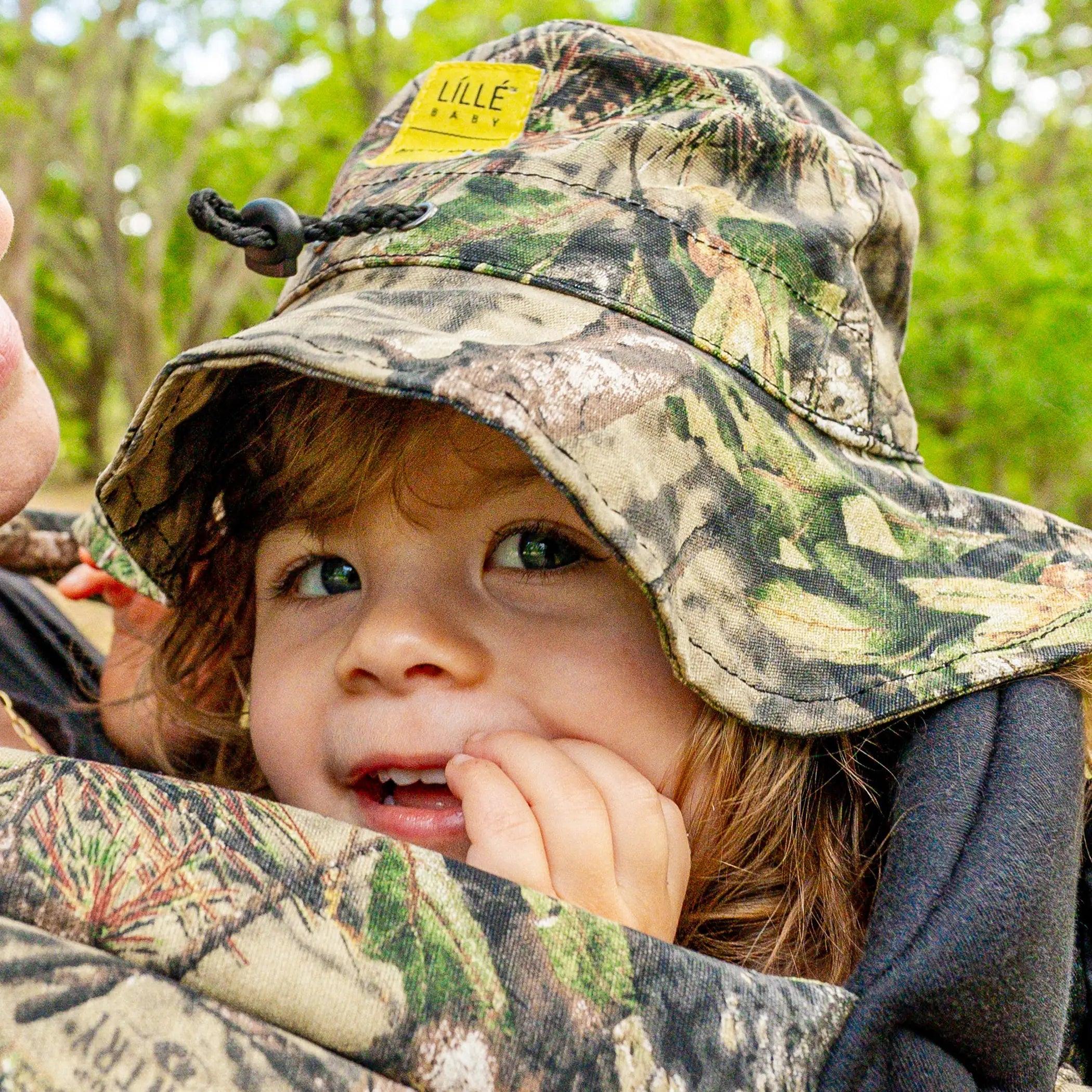 toddler wearing lillebaby x mossy oak bucket hat