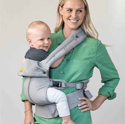 Mom in green shirt holding her baby in the All Seasons carrier