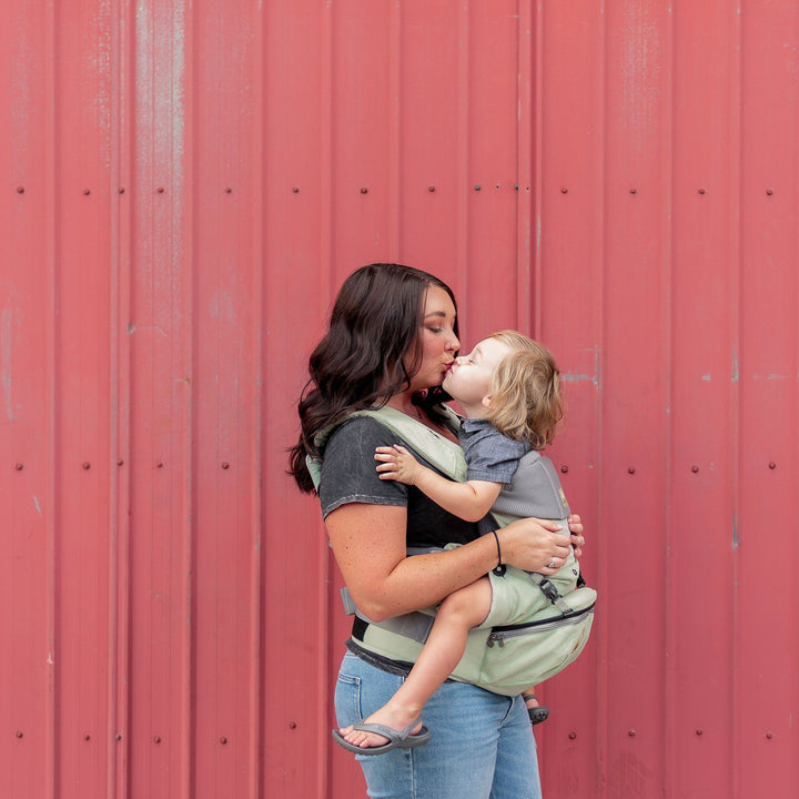 mom wearing baby in lillebaby seatme all seasons baby carrier in sage