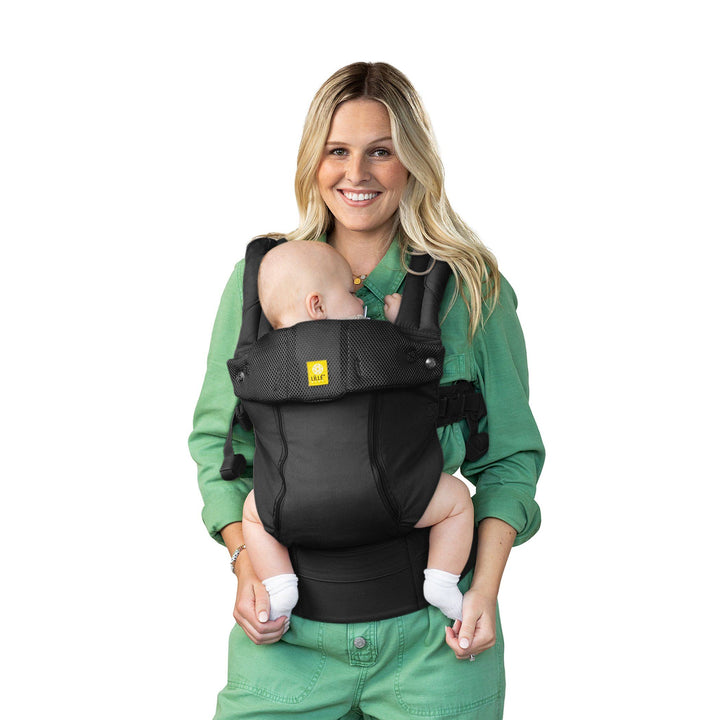 mom wearing baby in lillebaby complete all seasons baby carrier in black