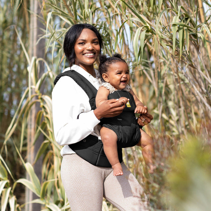 mom wearing baby in lillebaby complete all seasons baby carrier in black