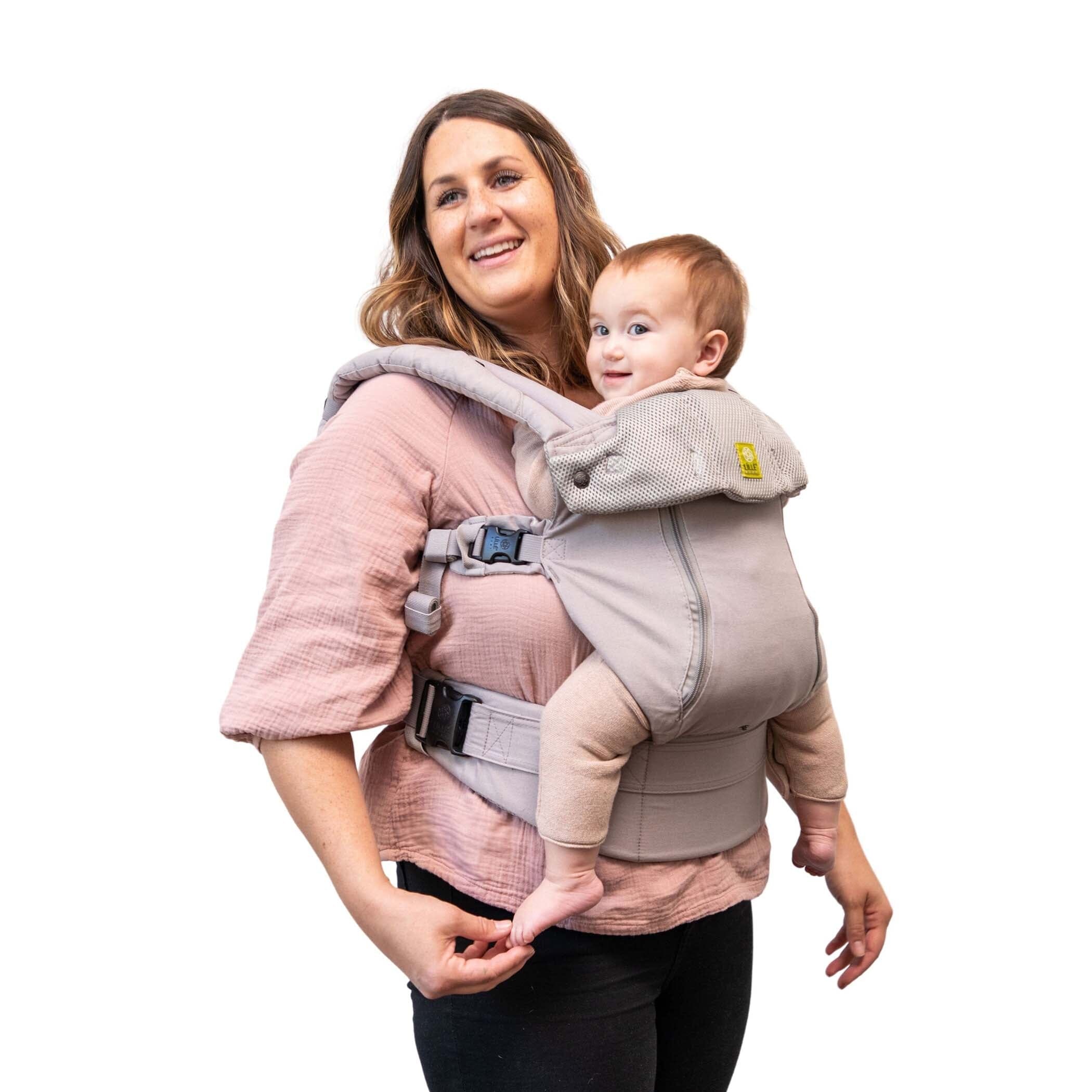 Plus size mom wearing 6 month old infant in inward seated ergonomic position