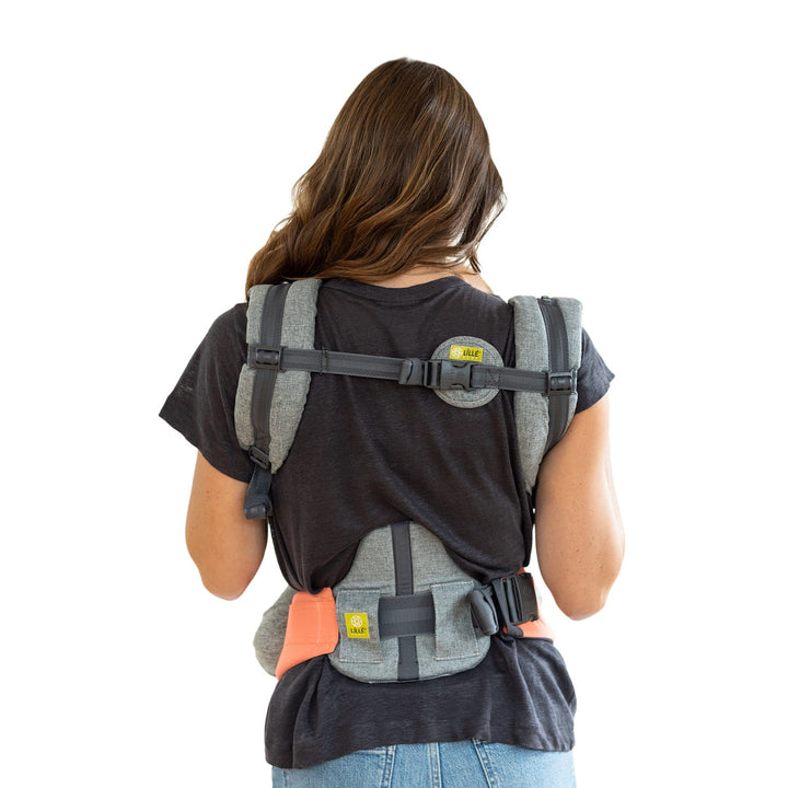 back image of mom wearing baby in lillebaby complete all seasons baby carrier in cool coral