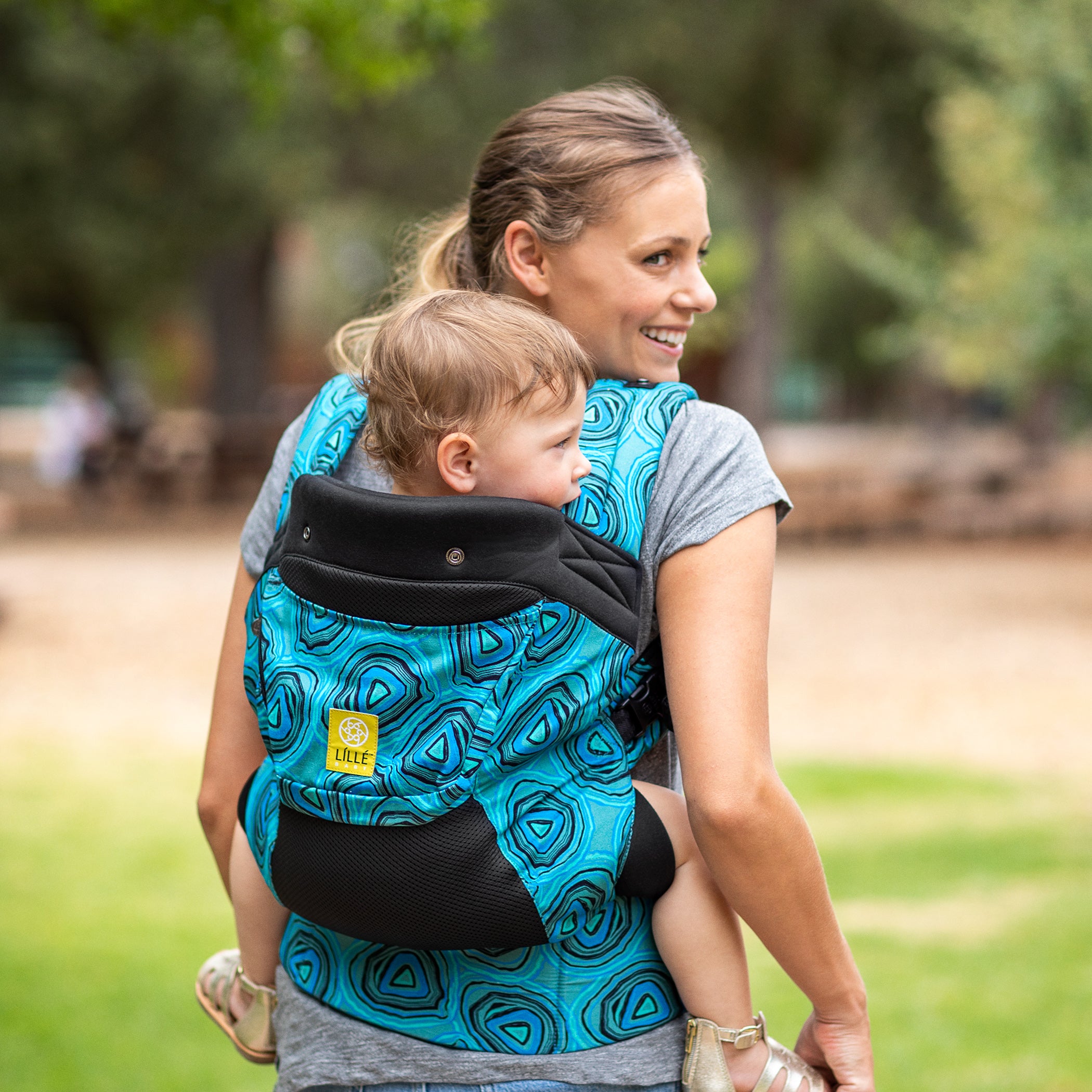 mom wearing baby in lillebaby carryon baby carrier in blue agate