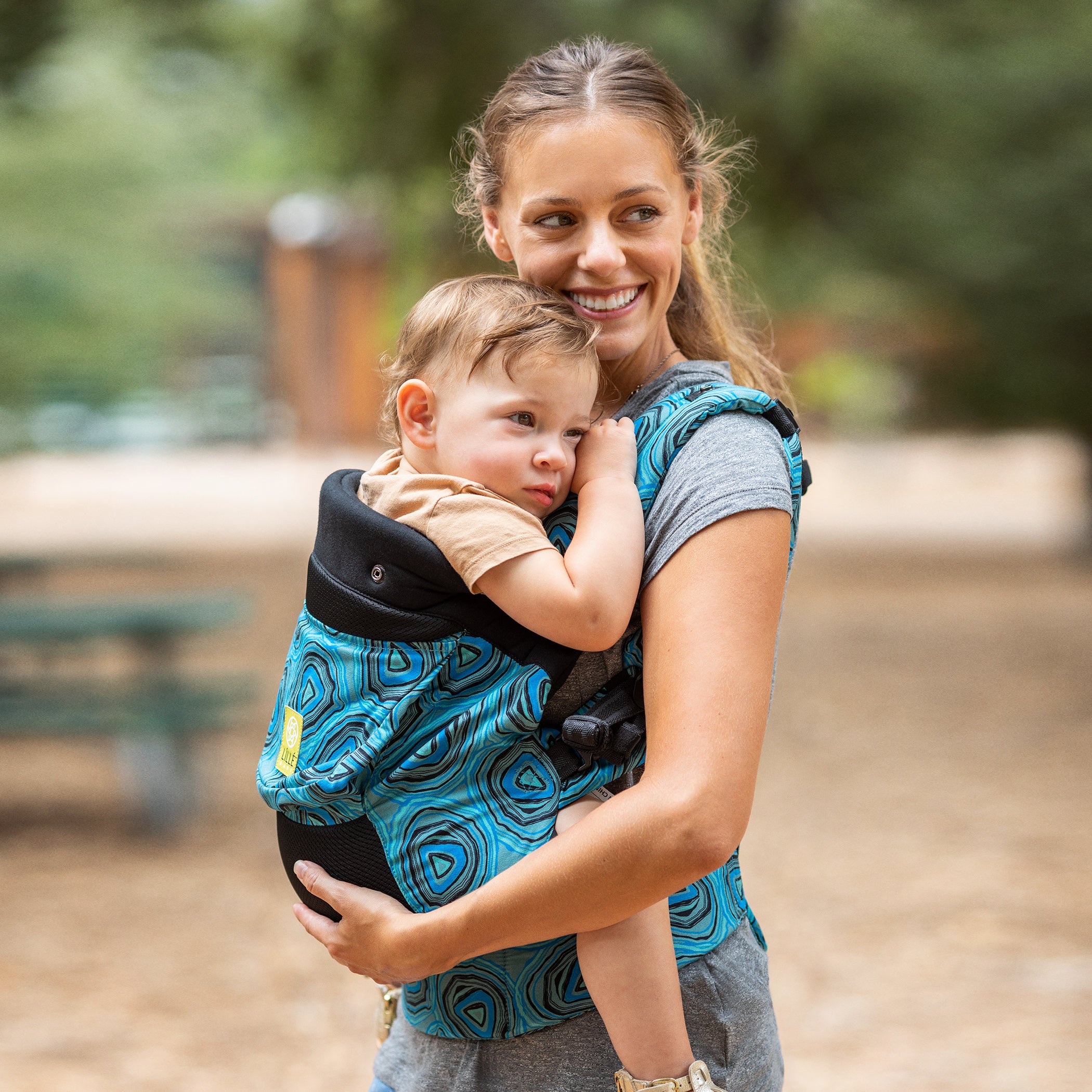 mom wearing baby in lillebaby carryon baby carrier in blue agate